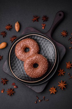 Koyu beton bir zemine çikolata parçacıkları serpiştirilmiş lezzetli çikolata kaplı donut.