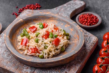 Lezzetli haşlanmış pirinç, biber, bezelye, kuşkonmaz fasulyesi ve havuç ve beton kaplama.