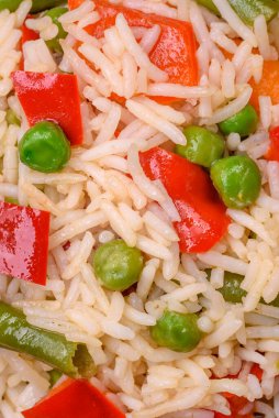 Lezzetli haşlanmış pirinç, biber, bezelye, kuşkonmaz fasulyesi ve havuç ve beton kaplama.