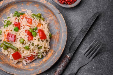 Lezzetli haşlanmış pirinç, biber, bezelye, kuşkonmaz fasulyesi ve havuç ve beton kaplama.