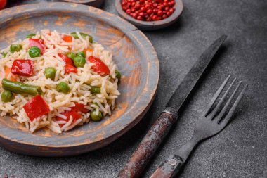 Lezzetli haşlanmış pirinç, biber, bezelye, kuşkonmaz fasulyesi ve havuç ve beton kaplama.