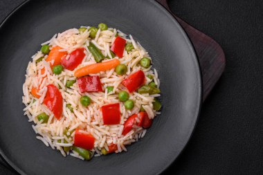 Lezzetli haşlanmış pirinç, biber, bezelye, kuşkonmaz fasulyesi ve havuç ve beton kaplama.