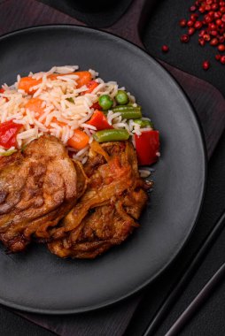 Lezzetli haşlanmış pilav, biber, bezelye, kuşkonmaz fasulye ve havuç ve çimento kaplı arka planda kızarmış tavuk.