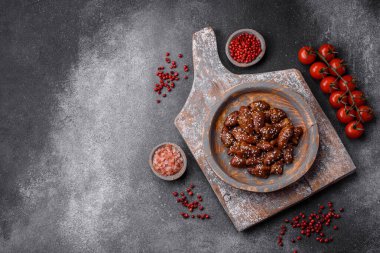 Soya sosunda kızartılmış tavuk kalbi. Tuzlu ve baharatlı bir tabakta beton bir arka planda.
