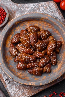 Soya sosunda kızartılmış tavuk kalbi. Tuzlu ve baharatlı bir tabakta beton bir arka planda.