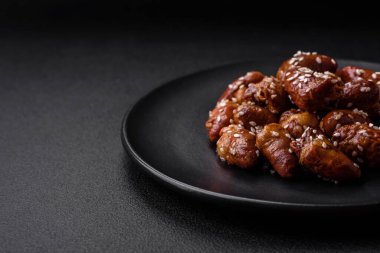 Soya sosunda kızartılmış tavuk kalbi. Tuzlu ve baharatlı bir tabakta beton bir arka planda.