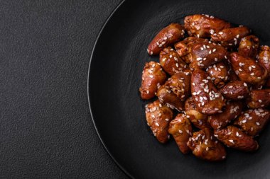 Soya sosunda kızartılmış tavuk kalbi. Tuzlu ve baharatlı bir tabakta beton bir arka planda.