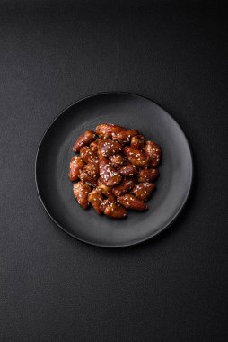 Soya sosunda kızartılmış tavuk kalbi. Tuzlu ve baharatlı bir tabakta beton bir arka planda.