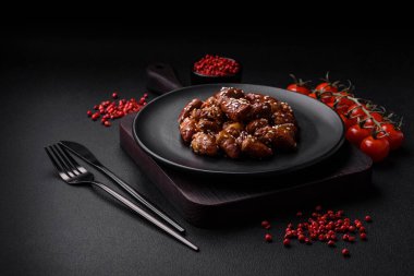 Soya sosunda kızartılmış tavuk kalbi. Tuzlu ve baharatlı bir tabakta beton bir arka planda.