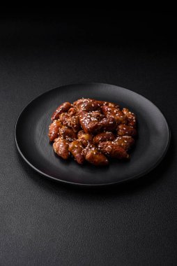 Soya sosunda kızartılmış tavuk kalbi. Tuzlu ve baharatlı bir tabakta beton bir arka planda.