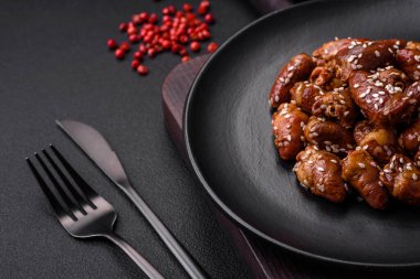 Soya sosunda kızartılmış tavuk kalbi. Tuzlu ve baharatlı bir tabakta beton bir arka planda.