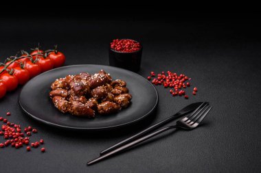 Soya sosunda kızartılmış tavuk kalbi. Tuzlu ve baharatlı bir tabakta beton bir arka planda.