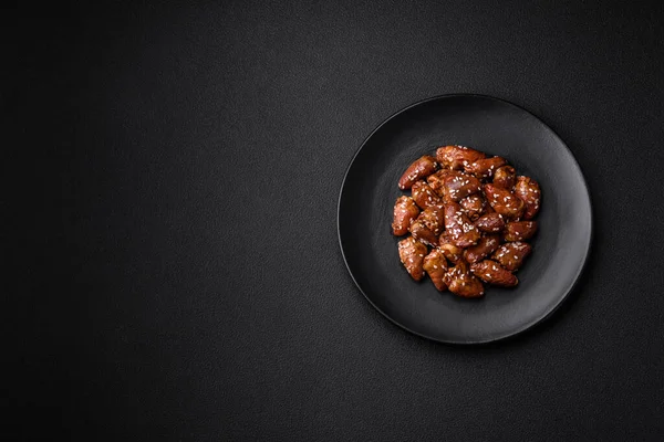 Soya sosunda kızartılmış tavuk kalbi. Tuzlu ve baharatlı bir tabakta beton bir arka planda.