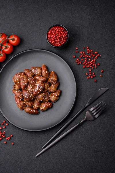 stock image Chicken hearts fried in soy sauce with salt and spices in a plate on a textured concrete background