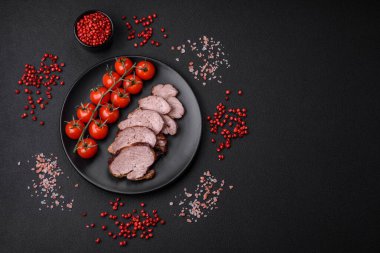 Tuzlu biftek, baharat ve otlar seramik tabakta koyu beton arka planda.