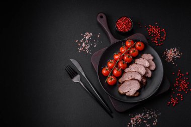 Tuzlu biftek, baharat ve otlar seramik tabakta koyu beton arka planda.