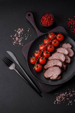 Tuzlu biftek, baharat ve otlar seramik tabakta koyu beton arka planda.