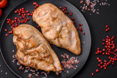 Lezzetli taze ızgara tavuk filetosu. Tuz, baharat ve otlar. Koyu beton arka planda seramik bir tabakta.