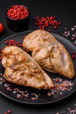 Lezzetli taze ızgara tavuk filetosu. Tuz, baharat ve otlar. Koyu beton arka planda seramik bir tabakta.