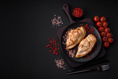 Lezzetli taze ızgara tavuk filetosu. Tuz, baharat ve otlar. Koyu beton arka planda seramik bir tabakta.