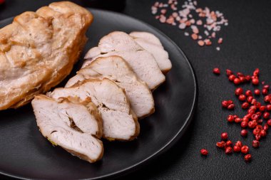 Lezzetli taze ızgara tavuk filetosu. Tuz, baharat ve otlar. Koyu beton arka planda seramik bir tabakta.