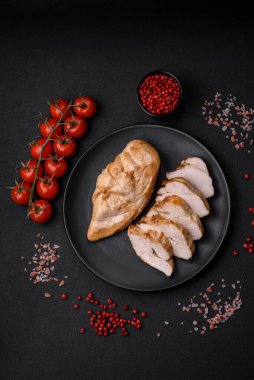 Lezzetli taze ızgara tavuk filetosu. Tuz, baharat ve otlar. Koyu beton arka planda seramik bir tabakta.