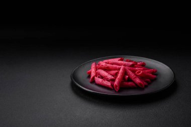 Beton arka planda pancar, peynir, tuz ve baharatlı lezzetli makarna.