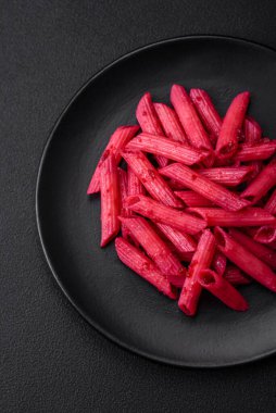 Beton arka planda pancar, peynir, tuz ve baharatlı lezzetli makarna.