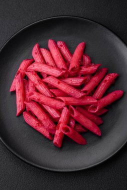 Beton arka planda pancar, peynir, tuz ve baharatlı lezzetli makarna.