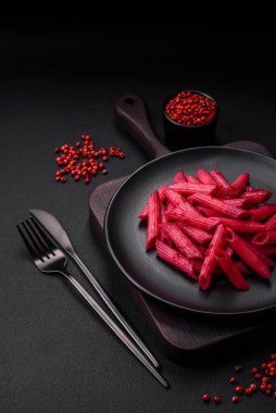 Beton arka planda pancar, peynir, tuz ve baharatlı lezzetli makarna.