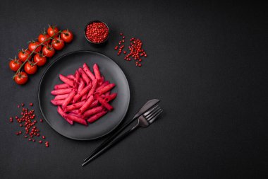 Beton arka planda pancar, peynir, tuz ve baharatlı lezzetli makarna.