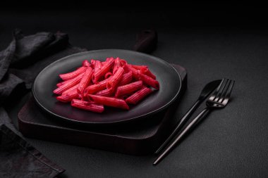 Beton arka planda pancar, peynir, tuz ve baharatlı lezzetli makarna.