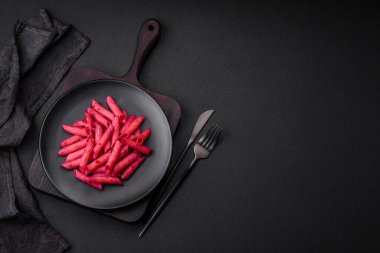 Beton arka planda pancar, peynir, tuz ve baharatlı lezzetli makarna.