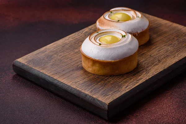 stock image Delicious tart with citrus filling and walnut cream on a textured concrete background