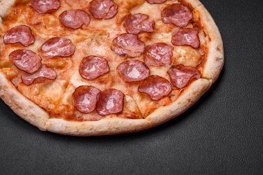 Salamlı, peynirli, domatesli, baharatlı ve esmer arkaplanlı taze pizza.