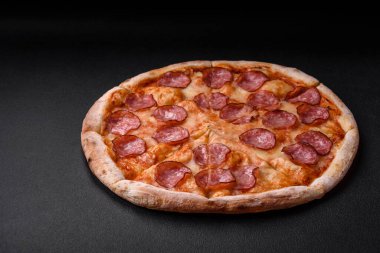 Salamlı, peynirli, domatesli, baharatlı ve esmer arkaplanlı taze pizza.