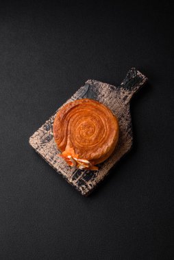 Turunçgil dolgulu yuvarlak hamur kruvasan ya da koyu beton arka planda New York rulosu