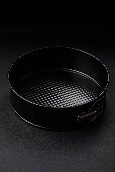 stock image Round metal black detachable baking dish for baking on a dark concrete background