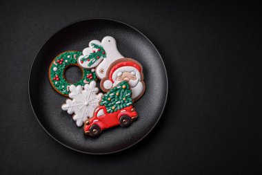 Taze lezzetli fırınlanmış Noel ya da koyu beton arka planda parlak renk temalı zencefilli kurabiyeler.