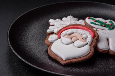 Taze lezzetli fırınlanmış Noel ya da koyu beton arka planda parlak renk temalı zencefilli kurabiyeler.