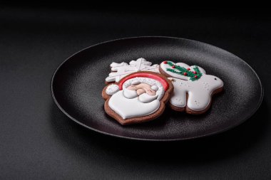 Taze lezzetli fırınlanmış Noel ya da koyu beton arka planda parlak renk temalı zencefilli kurabiyeler.