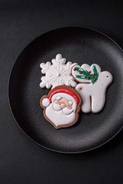 Taze lezzetli fırınlanmış Noel ya da koyu beton arka planda parlak renk temalı zencefilli kurabiyeler.