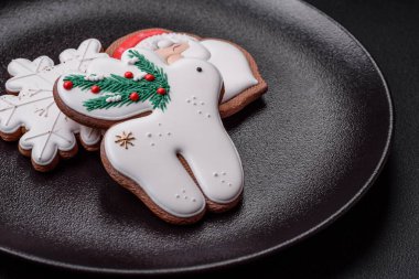 Taze lezzetli fırınlanmış Noel ya da koyu beton arka planda parlak renk temalı zencefilli kurabiyeler.