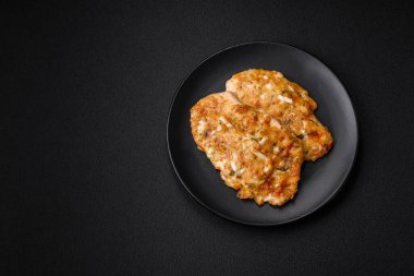 Lezzetli kızarmış tavuk göğsü hardal, tuz, baharat ve peynirli koyu beton arka planda.