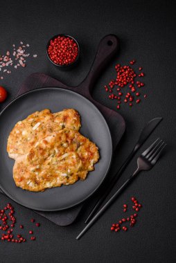 Lezzetli kızarmış tavuk göğsü hardal, tuz, baharat ve peynirli koyu beton arka planda.