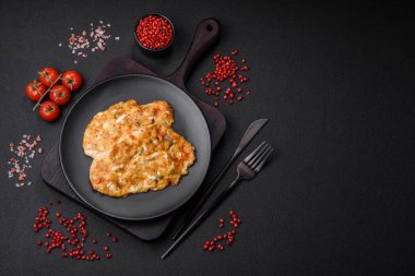 Lezzetli kızarmış tavuk göğsü hardal, tuz, baharat ve peynirli koyu beton arka planda.