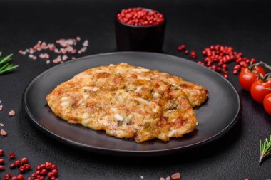 Lezzetli kızarmış tavuk göğsü hardal, tuz, baharat ve peynirli koyu beton arka planda.