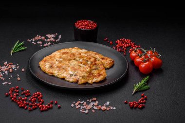 Lezzetli kızarmış tavuk göğsü hardal, tuz, baharat ve peynirli koyu beton arka planda.