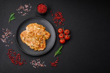 Lezzetli kızarmış tavuk göğsü hardal, tuz, baharat ve peynirli koyu beton arka planda.