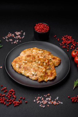 Lezzetli kızarmış tavuk göğsü hardal, tuz, baharat ve peynirli koyu beton arka planda.